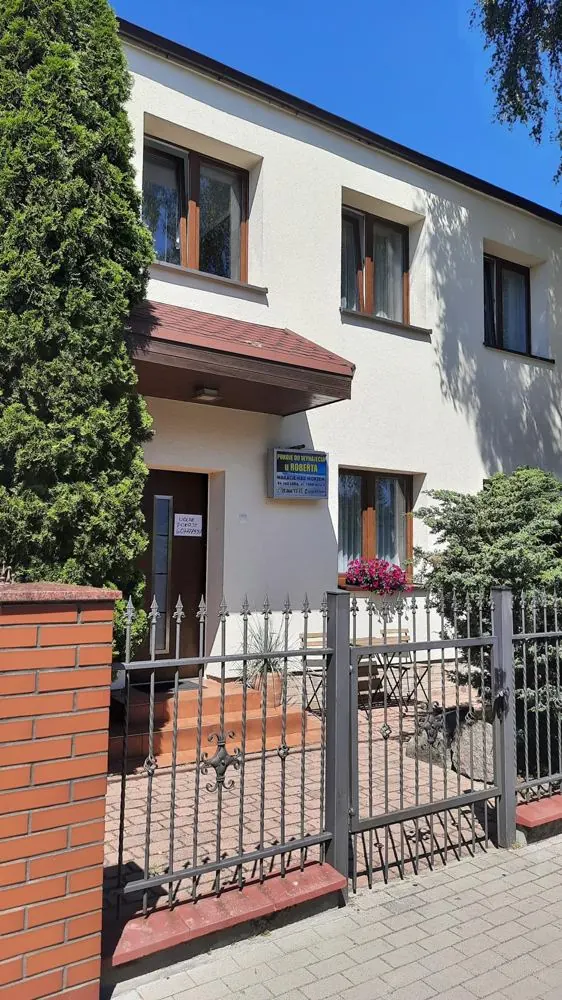Fasada domu z bramą i tabliczką Pokoje u Roberta